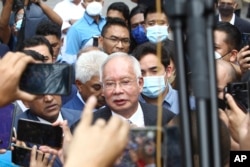 Mantan Perdana Menteri Malaysia Najib Razak, tengah, berbicara kepada para pendukungnya di luar di Pengadilan Banding di Putrajaya, Malaysia Selasa, 23 Agustus 2022. (Foto: AP)