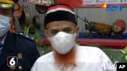 In this image made from SCTV video shot Aug. 17, 2022, convicted Muslim militant Umar Patek talks to the media after receiving his sentence reduction letter during a ceremony at Porong Prison in Sidoarjo, Central Java, Indonesia.