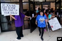 FILE - Family, parents and friends file out of a meeting where Uvalde School District Police Chief Pete Arredondo was dismissed by the Board of Trustees of the Uvalde Consolidated Independent School District, in Uvalde, Texas, Aug. 24, 2022.