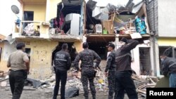 Miembros de las fuerzas de seguridad revisan el área de una explosión que dejó heridos y otros muertos y destruyó varias casas y vehículos, según informes de medios locales, en el sur de Guayaquil, Ecuador, 14 de agosto de 2022.