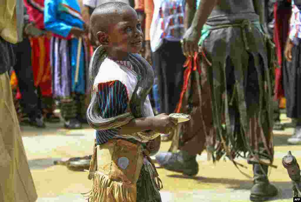 Seorang anak laki-laki Sudan membawa seekor ular ketika ratusan demonstran berkumpul di luar aula Al-Sadaka di ibu kota Khartoum selama pertemuan inisiatif politik &quot;Panggilan Rakyat Sudan&quot; untuk mendukung insiatif politik yang diprakarsai oleh militer Sudan.(Foto: AFP)