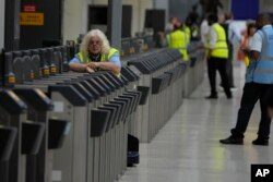 Petugas keamanan mengawasi gerbang kosong di peron Stasiun Waterloo, London, saat anggota serikat pekerja Rail, Maritime and Transport (RMT) mulai menggelar aksi mogok, Kamis, 18 Agustus 2022.(AP Photo /Frank Augstein)