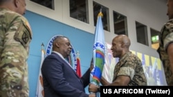 美国非洲司令部推特账户发布的照片显示新任司令兰利将军从国防部长奥斯汀手中接过旗帜。(2022年8月9日)