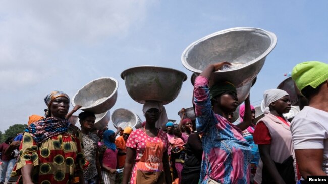 FILE - Head porters march in the streets to protests recent economic hardships, in Accra, Ghana, June 29, 2022.