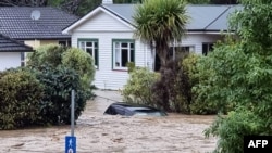 Mobil dan rumah yang terendam banjir dari Sungai Maitai yang meluap di Nelson tengah di Pulau Selatan Selandia Baru, dari selebaran yang diambil pada 17 Agustus 2022 oleh outlet media lokal Andrew App, dirilis 18 Agustus 2022. (Sara HOLLYMAN / ANDREW APP / AFP)