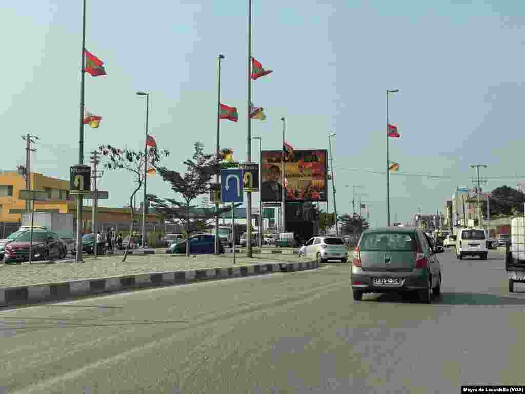 Bandeiras dos partidos UNITA e FNLA e cartaz do líder do MPLA, João Lourenço, numa estrada de Luanda.