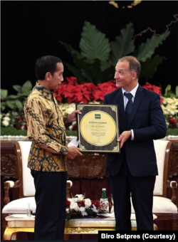 Presiden Jokowi menerima penghargaan atas pencapaian Indonesia dalam Swasembada Beras yang diserahkan oleh Dirjen IRRI Jean Balie di Istana Merdeka, Jakarta, Minggu (14/8). (Foto: Biro Setpres )