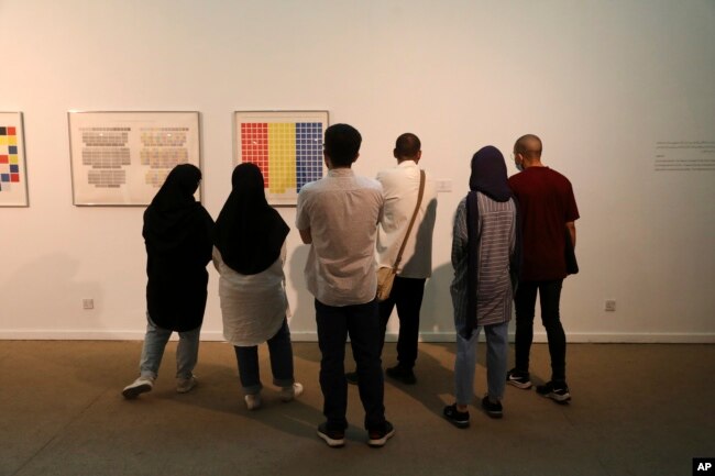 Visitors look at artworks by the American artist Sol Lewitt while visiting a 19th and 20th-century American and European minimalist and conceptual masterpieces show at the Tehran Museum of Contemporary Art in Tehran, Iran, Aug. 2, 2022.