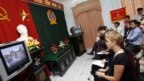 Các nhà báo và đại diện ngoại giao tham dự một phiên tòa xét xử Linh mục bất đồng chính kiến Nguyễn Văn Lý tại một tòa án ở Huế năm 2007 qua màn hình TV trong khuôn viên tòa án.