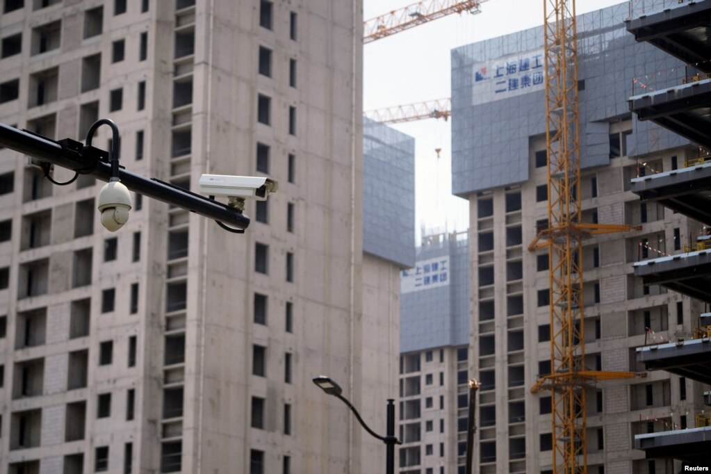 上海一处正在修建的公寓楼盘旁竖立着一个监控摄像头。（2022年7月20日）(photo:VOA)