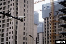 上海一处正在修建的公寓楼盘旁竖立着一个监控摄像头。（2022年7月20日）