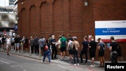 FILE - People queue up to receive monkeypox vaccinations during a pop-up clinic at Guy's Hospital in central London, July 30, 2022. 
