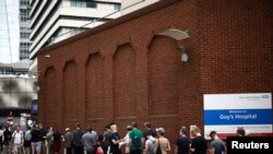 FILE - People queue up to receive monkeypox vaccinations during a pop-up clinic at Guy's Hospital in central London, Taken 7.30.2022