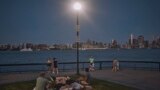 FILE - People spend time at the park at dusk during a summer heat wave, July 21, 2022, in Hoboken, New Jersey. The continental U.S. in July set a record for overnight warmth, providing little relief from the day’s sizzling heat, meteorologists said.