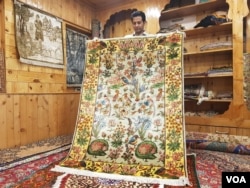 A carpet weaver shows a carpet in his showroom in Srinagar, Jammu and Kashmir in Indian-administered Kashmir. (M. Hamid/VOA)