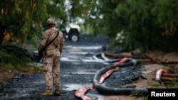 A soldier stands guard in the area of ​​a collapsed coal mine where miners remain trapped, in Sabinas, Coahuila state, Mexico, August 15, 2022.