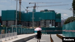 一名女子走過北京的一處住宅樓建築工地。（2022年7月15日）