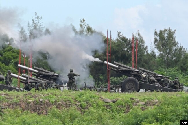 Taiwan military soldiers fire the 155-inch howitzers during a live fire anti landing drill in the Pingtung county, southern Taiwan on August 9, 2022. (Photo by Sam Yeh / AFP)