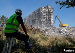 Workers demolish a multi-story apartment block, which was destroyed in the course of Ukraine-Russia conflict in the Russian-controlled city of Mariupol, Ukraine, August 23, 2022.