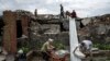 Volunteers clear rubble near Chernihiv, Ukraine, Aug. 13, 2022.