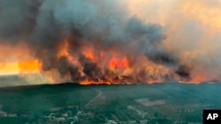 FILE - Photo provided by the fire brigade of the Gironde region shows flames consume trees at a forest fire in Saint Magne, south eastern France, Aug. 10, 2022. 