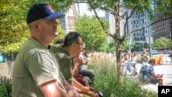 FILE - Army Staff Sgt. Jeff Deslauriers, left, listens as names of Sept. 11 victims are read, Sept. 11, 2021, in New York. A U.S. judge on Aug. 26, 2022, recommended that 9/11 victims not be allowed to seize Afghan central bank assets to satisfy judgments against the Taliban.