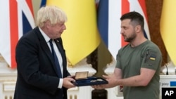 El presidente de Ucrania, Volodymyr Zelenskyy, a la derecha, premia al primer ministro británico, Boris Johnson, durante su reunión en Kyiv, Ucrania, el miércoles 24 de agosto de 2022. Johnson recibió la medalla de Honor de la Libertad de Ucrania en reconocimiento a la asistencia militar británica al país devastado por la guerra. (Foto AP/Andrés Kravchenko)