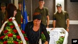 Lyudmila Kolesnik, nëna e aktivistes Julia Chaika, vajton mbi arkivolin e saj gjatë një shërbimi funerali në Zaporizhzhia, Ukrainë, të dielën, 21 gusht 2022.