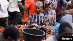 FILE - A woman counts money at Mile 12 International Market in Lagos, Nigeria, May 13, 2022.