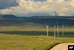 Clouds cast shadows near wind turbines at a wind farm along the Montana-Wyoming state line on Monday, June 13, 2022.