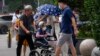 FILE - A man pushes an elderly woman in a wheelchair in Beijing, July 5, 2022.