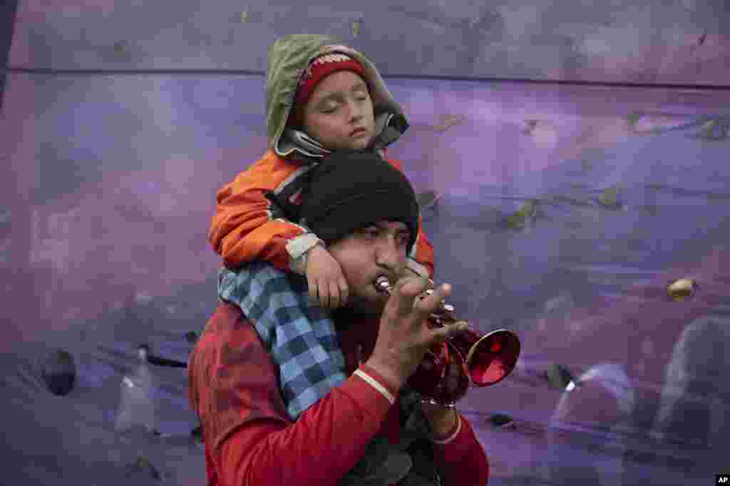 A child falls asleep as his father plays a pocket trumpet during a demonstration demanding more money for social programs that support unemployed people in Buenos Aires, Argentina, Aug. 10, 2022.