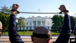 FILE - A member of the Uyghur American Association rallies in front of the White House, Oct. 1, 2020, after marching from Capitol Hill in Washington, in support of the Uyghur Forced Labor Prevention Act. The legislation was signed into law in late 2021.