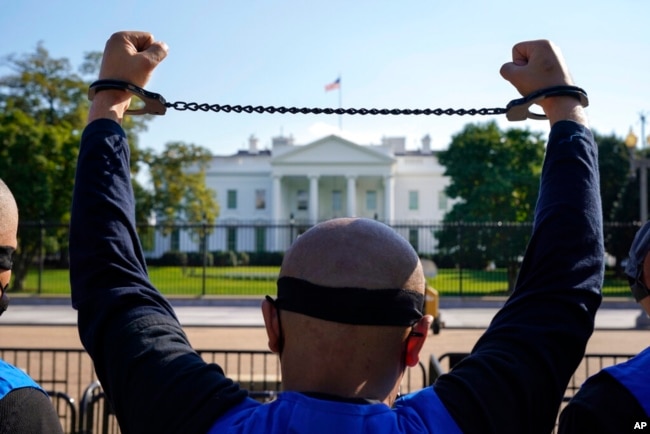 FILE - A member of the Uyghur American Association rallies in front of the White House, Oct. 1, 2020, after marching from Capitol Hill in Washington in support of the Uyghur Forced Labor Prevention Act. The legislation was signed into law in late 2021.