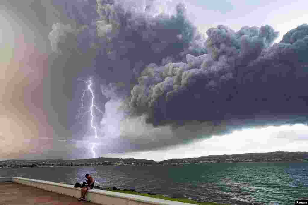 A lightning strikes through smoke from fuel storage tanks that exploded near Cuba's supertanker port in Matanzas, Cuba, Aug. 8, 2022.