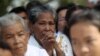 FILE - A woman prays at the Choeung Ek memorial during the annual "Day of Anger", where people gather to remember those who perished during the communist Khmer Rouge regime, in Phnom Penh, Cambodia, May 20, 2016.