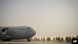 This image taken by the U.S. Air Force shows U.S. Army troops from the 1st Combined Arms Battalion, 163rd Cavalry Regiment, board a C-17 Globemaster III during an exercise at Ali Al Salem Air Base, Kuwait, Aug. 10, 2022.