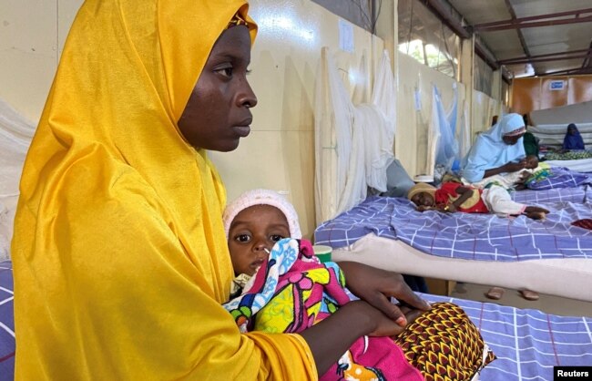 A woman carries a malnourished child at a treatment center in Damaturu, Yobe, Nigeria, Aug. 24, 2022.