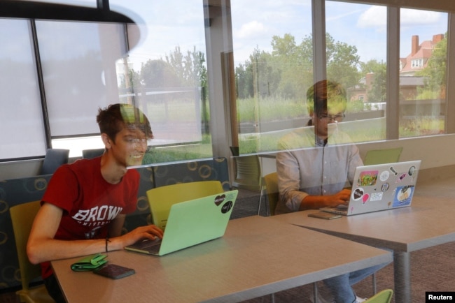 Hlib Burtsev and Oleksii Shebanov, both from Ukraine, check their email in the common area of their dorm ahead of their first year at Brown University in Providence, Rhode Island, U.S., August 16, 2022. (REUTERS/Brian Snyder)