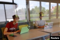 Hlib Burtsev and Oleksii Shebanov, both from Ukraine, check their email in the common area of their dorm ahead of their first year at Brown University in Providence, Rhode Island, U.S., August 16, 2022. REUTERS/Brian Snyder