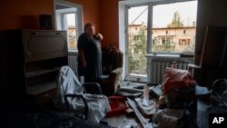 A woman reacts at her damaged apartment after a rocket attack early Wednesday morning, in Kramatorsk, eastern Ukraine, Aug. 31, 2022. 