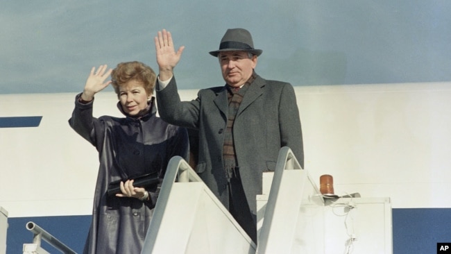 FILE - Mikhail Gorbachev with wife, Raisa, wave before boarding a plane on departure from New York's John F. Kennedy Airport, December 1988.