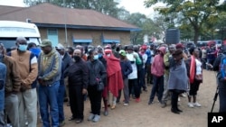 People line up to vote at the Moi avenue Primary School in Nairobi, Kenya, August 9, 2022. Polls opened Tuesday in Kenya's unusual presidential election, where a longtime opposition leader who is backed by the outgoing president faces the deputy pr