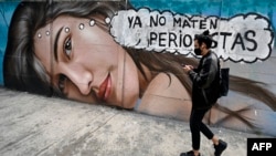 FILE - A man walks past a mural reading 'Stop killing journalists' in Mexico City, Feb. 13, 2022. A journalist who ran an online local news program was shot to death Monday in southern Mexico, making him the 15th media worker killed so far this year nationwide. 