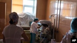 Misha, a baby born prematurely at 33 weeks, is checked on by staff in a room fortified with sandbags in the window at the Pokrovsk Perinatal Hospital, in Pokrovsk, Donetsk region, Aug. 15, 2022.
