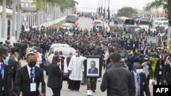 Le cortège transportant la dépouille de l'ancien président angolais José Eduardo dos Santos jusqu'à sa dernière demeure marche derrière le corbillard lors de ses funérailles d'État à la Praca da Republica à Luanda le 28 août 2022.