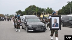 Le cortège transportant la dépouille de l'ancien président angolais José Eduardo dos Santos jusqu'à sa dernière demeure marche derrière le corbillard lors de ses funérailles d'État à la Praca da Republica à Luanda le 28 août 2022.