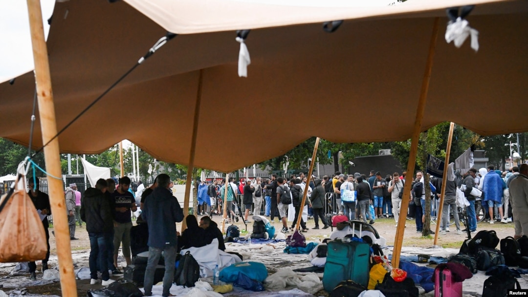 Los refugiados esperan al aire libre en el suelo húmedo del principal centro de recepción de solicitantes de asilo, en Ter Apel, Países Bajos, el 17 de agosto de 2022.