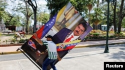 Un hombre porta un cartel con la imagen del presidente de Venezuela, Nicolás Maduro, en Barinas, Venezuela, 10 de enero de 2022.