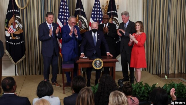 U.S. President Joe Biden is applauded after signing the Inflation Reduction Act of 2022 into law, in the State Dining Room of the White House in Washington, Aug. 16, 2022.